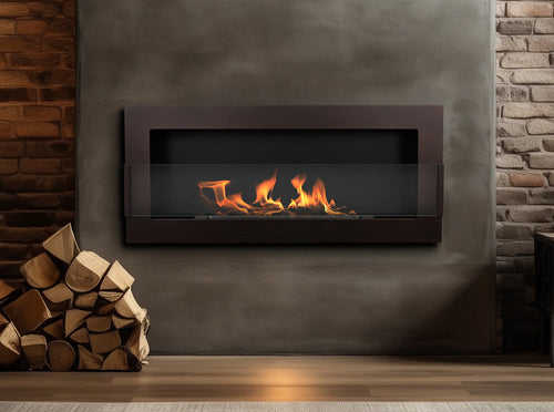 Lit brown 900 × 400 bioethanol fireplace on a grey wall, with exposed brickwork and stacked logs nearby.