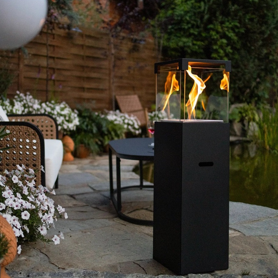 Outdoor patio with a fire pit, chairs, and decorative elements.