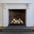 FENIKS black bioethanol insert lit in a brick-lined fireplace with a white surround and decorative logs